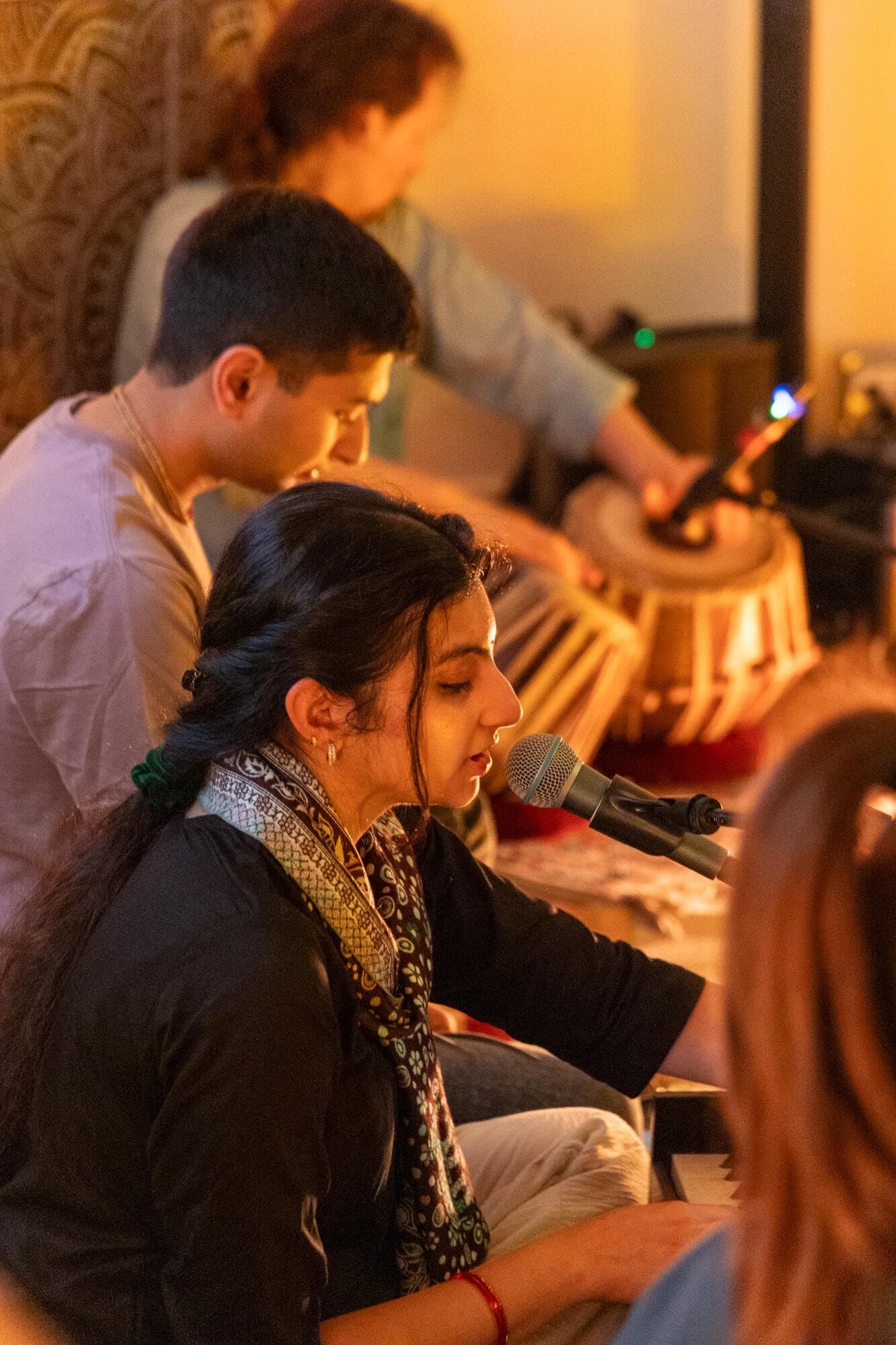 A singer and a tabla player performing live, up close